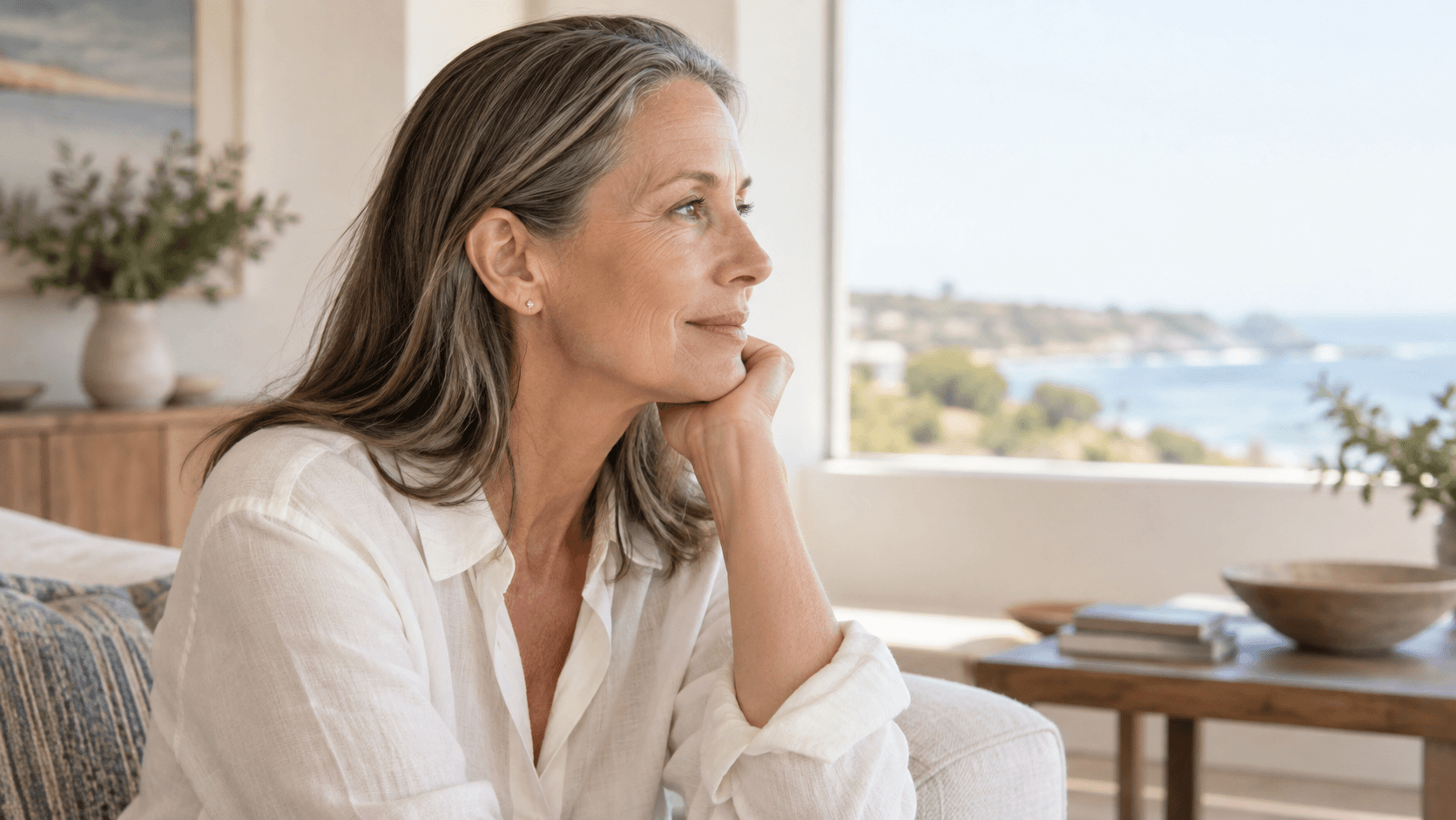 Side profile of a woman with gray-brown hair tucked behind her ear.